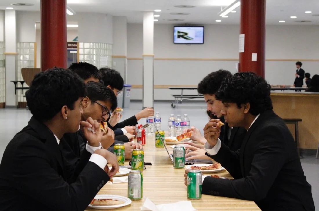 Students eating lunch together at a long table