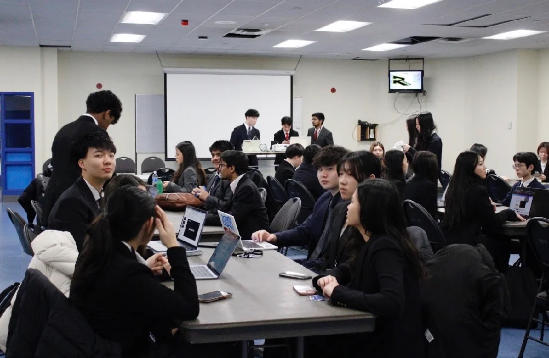 Teams working at long tables in the competition room